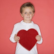 Boy holding heart-shaped box.