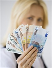 Businesswoman holding Euro banknotes.