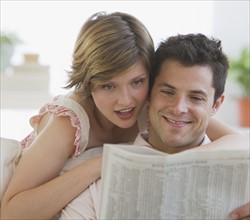 Couple reading newspaper.