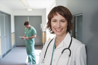 Female doctor leaning on wall.