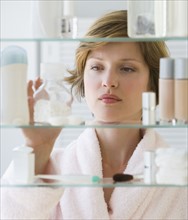 Woman looking in medicine cabinet.