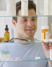 Man looking in medicine cabinet.