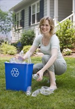 Woman filling recycling bin.