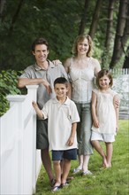 Family next to fence in yard.