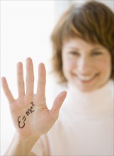 Woman with formula written on hand.
