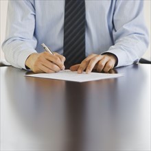 Businessman writing at table.