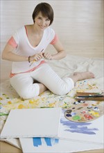 Woman painting on floor.