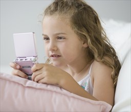 Girl playing handheld video game.