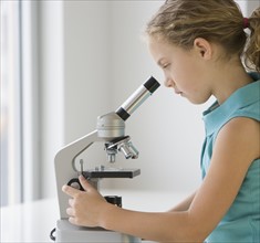Girl looking into microscope.