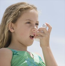 Girl using asthma inhaler.