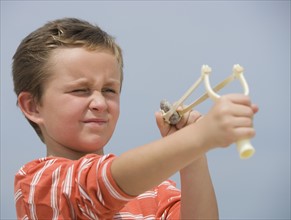 Boy aiming slingshot.