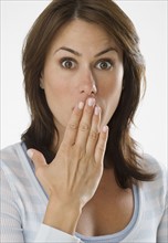 Woman looking surprised with hand over mouth.