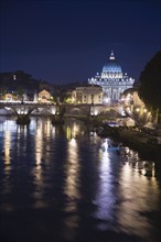 The Tiber River with St. Peter’s Basilica at night, Italy .