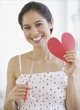 Woman holding cut out paper heart.
