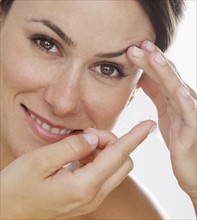 Woman putting in contact lens.