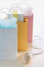 Gift bags next to computer mouse.
