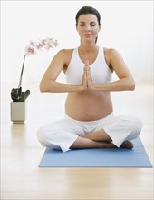 Pregnant woman practicing yoga.