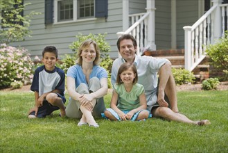 Family sitting on lawn.