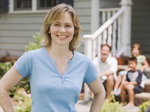 Portrait of woman with family in background.