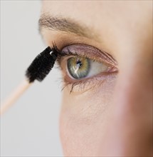 Woman applying mascara.