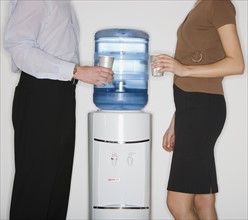 Businesspeople next to water cooler.