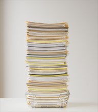 Large stack of paperwork in wire basket.