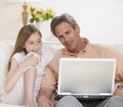 Father and daughter looking at laptop.