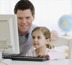 Father and daughter looking at computer.