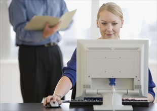 Businesswoman using computer at desk.