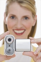Woman holding small video camera.