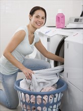 Woman talking laundry out of dryer.