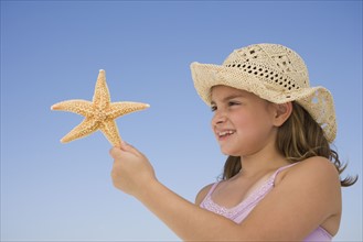 Girl holding starfish.