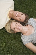 Couple laying in grass.