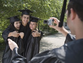 Group of college graduates having photograph taken.