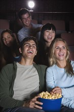 Couple laughing in movie theater.