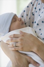 Mother holding newborn in hospital.