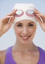 Woman wearing swimming cap and goggles.
