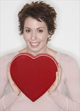 Woman holding heart-shaped box.