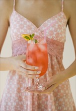 Woman holding cocktail.