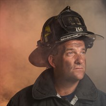 Male firefighter in smoke.
