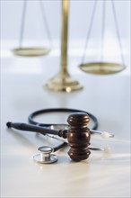 Gavel on stethoscope with scales in background.