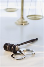 Gavel on handcuffs with scales in background.
