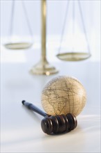 Gavel and globe with scales in background.