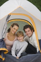 Family sitting in tent.