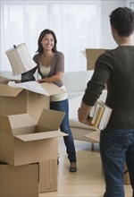 Multi-ethnic couple packing moving boxes.