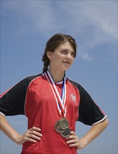 Female athlete with medals around neck.