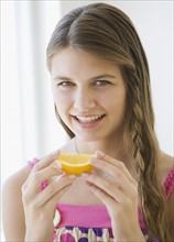 Girl eating orange wedge.