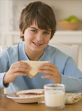 Boy eating sandwich.