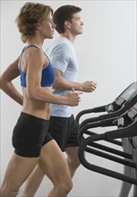 Couple running on treadmills.