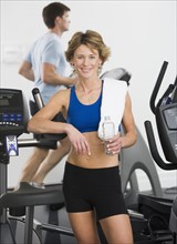 Woman leaning on treadmill.